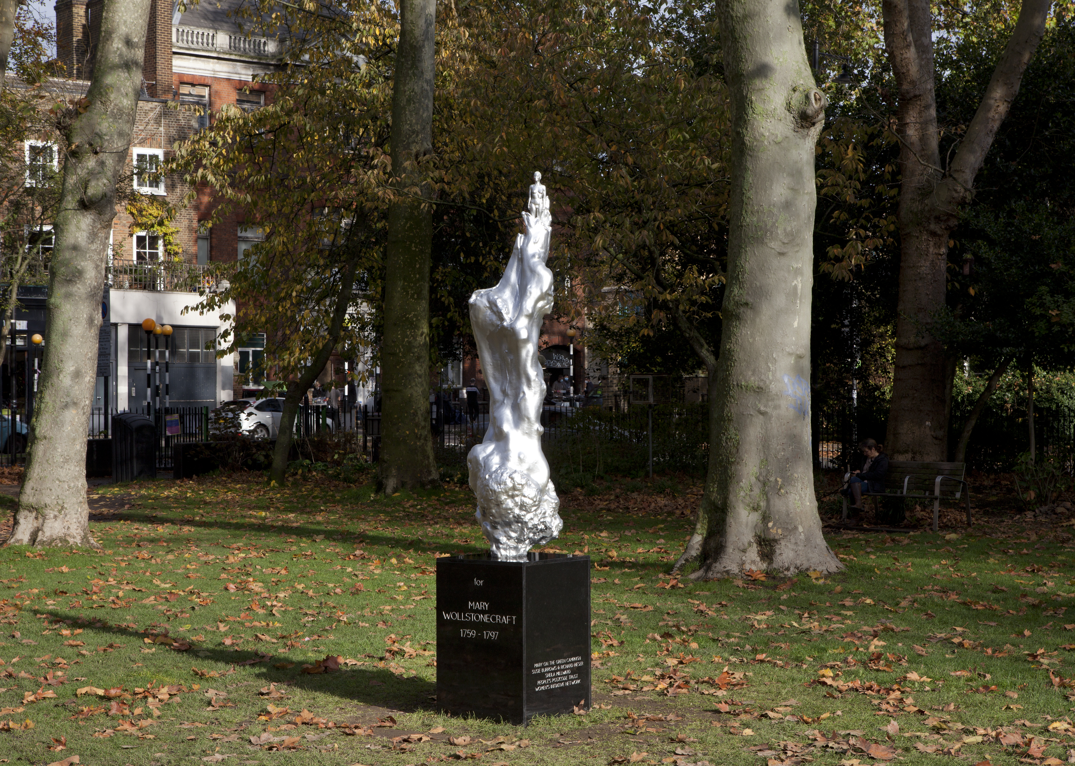 photo of a silver statue of Mary Wollstonecraft, whose body merges into a wave-like column
